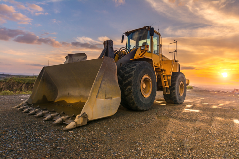 Heavy-duty front-end loader at sunset on a job site — highlighting the role of TRC lubricants in construction equipment performance and longevity.