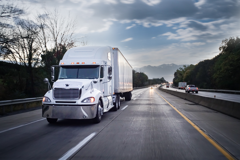 White semi-truck driving on highway — representing fast delivery of Diesel Laptops diagnostic tools and repair equipment.